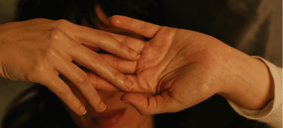 Two hands gently touching, set against a background of subtle, muted tones.
