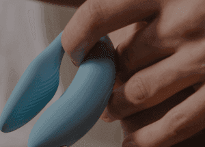 Eine Hand hält einen blauen Vibrator.